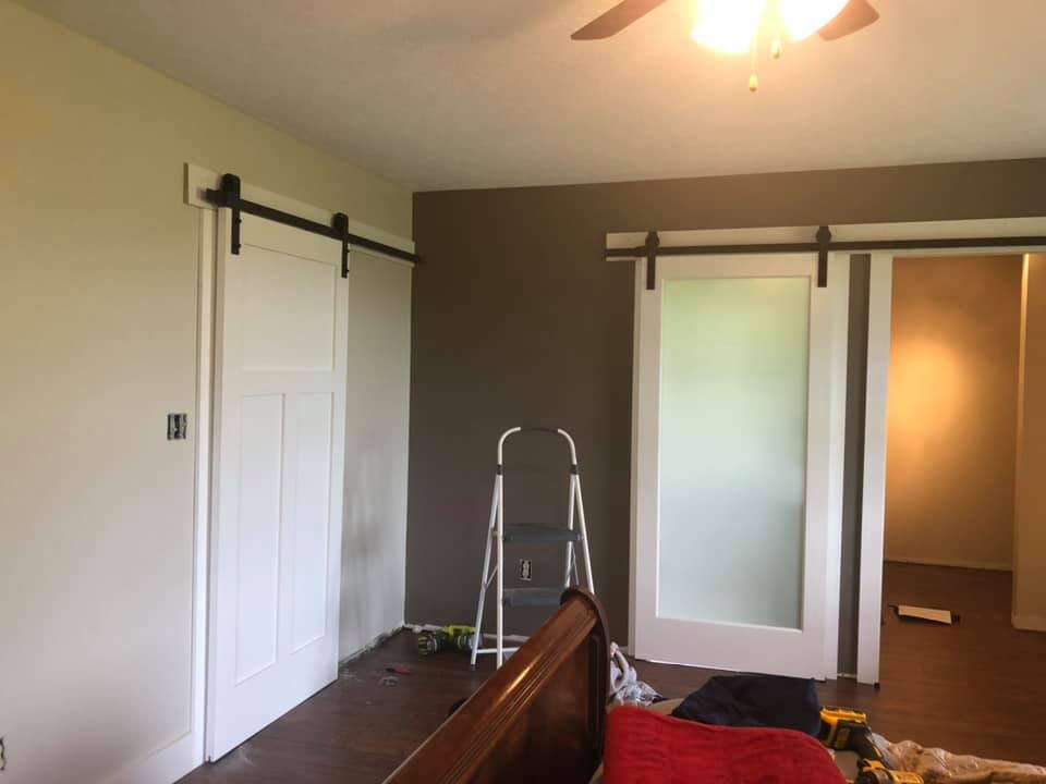 Pair of white sliding barn doors: a shaker panel and a frosted glass door