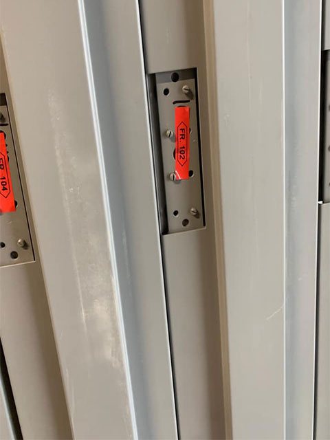 Grey hollow metal steel door frames with hinge reinforcements and orange frame tags