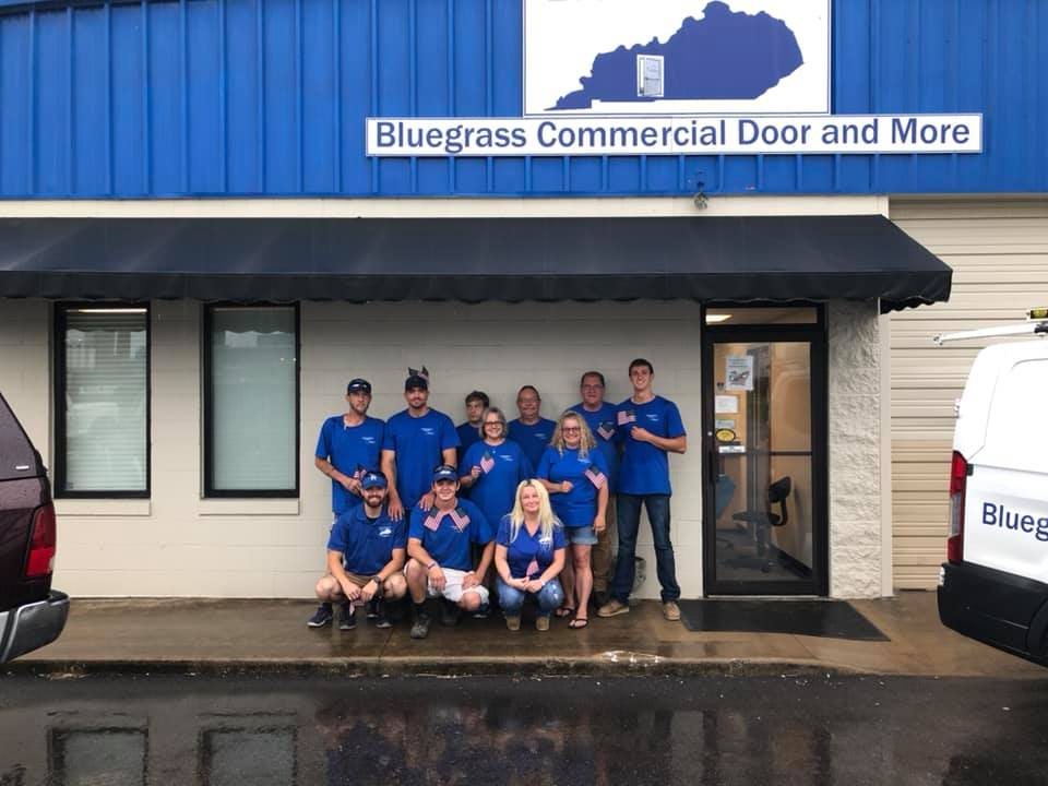 The Bluegrass Commercial Door & More team in blue company shirts in front of the shop in Bowling Green